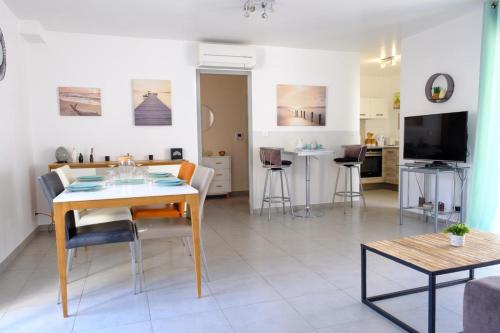 un salon avec une table et une salle à manger dans l'établissement Beautiful T3 with balcony near downtown, à Sainte-Maxime