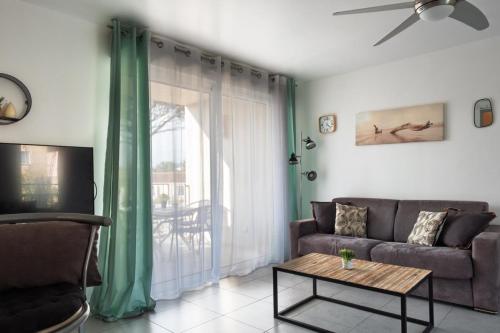 un salon avec un canapé et une table dans l'établissement Beautiful T3 with balcony near downtown, à Sainte-Maxime