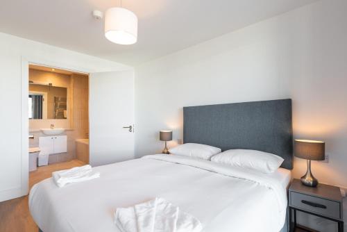 a bedroom with a large white bed and a bathroom at Alto Frascati Blackrock in Blackrock