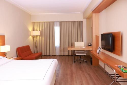 a hotel room with a bed and a desk and a television at Anemon Kent İskenderun Otel in İskenderun