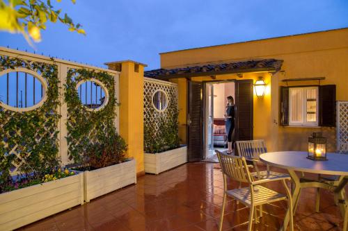 a patio with a table and chairs next to a building at The Inn at the Spanish Steps Luxury Collection - The Inn at the Spanish Steps in Rome