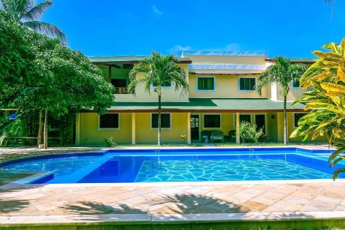 a villa with a swimming pool in front of a house at Modern Girasoli Suites 08 in Malindi