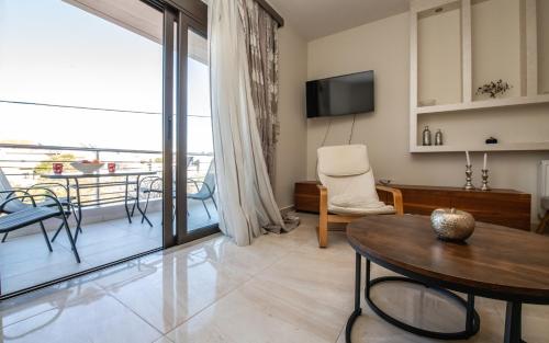 a living room with a table and a balcony at Xristina Home in Afantou