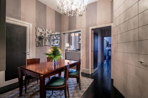 a dining room with a table and chairs and a chandelier at The Inn at the Spanish Steps Luxury Collection - The Inn at the Spanish Steps in Rome