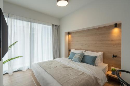a bedroom with a large bed and a large window at Silk Athens Urban Collection in Athens