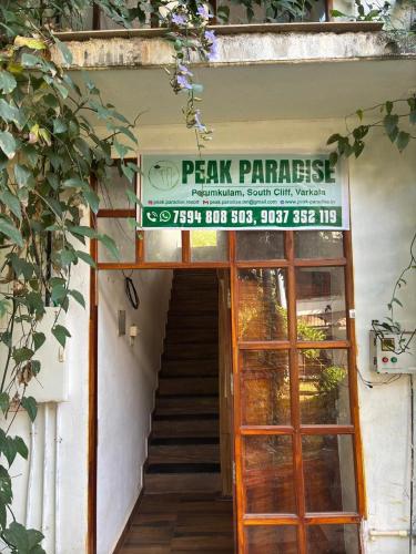 a sign over a door with a stairway leading into a building at Peak Paradise Resort in Varkala
