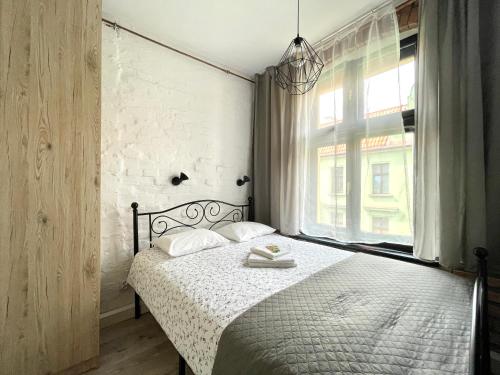 a bedroom with a bed and a large window at Copernicus Street Apartment - Broken Flowers and Twin Peaks in Toruń