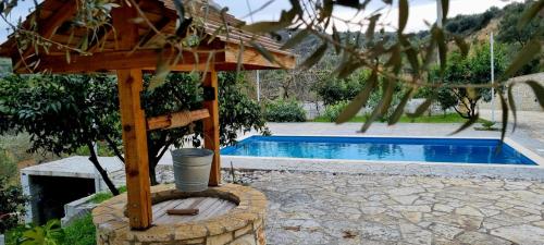 a wooden structure next to a swimming pool at Hillside Villa in Mifol
