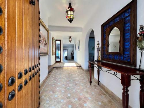 a hallway with a table and a mirror at Beach Front Villa Al Andalus in Restinga Smir