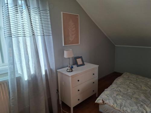 a bedroom with a bed and a lamp on a dresser at Dom z Duszą w Centrum Zwierzyńca in Zwierzyniec