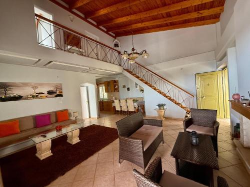 a living room with a couch and a staircase at Villa Nefeli in Piqeras
