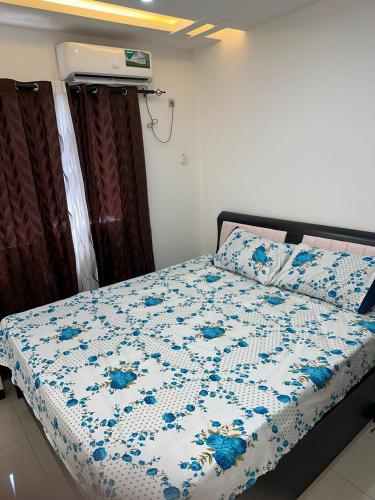 a bedroom with a bed with a blue and white comforter at Appartement 3 chambres in Conakry