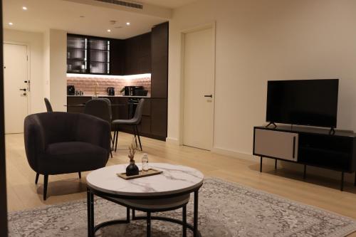 a living room with a television and a table and chairs at Luxury 2 Bed 2 Bath City Apartment in London