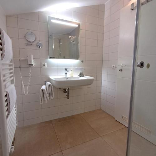 a white bathroom with a sink and a mirror at Hölbinger Alm - Apartments in Anger