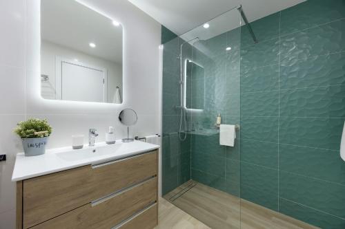 a bathroom with a shower with a sink and a mirror at Casa Azul in Portimão