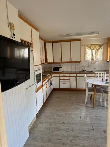 a kitchen with white cabinets and a table at Brunsbo G:a Biskopsgård Hotell & Konferens in Skara