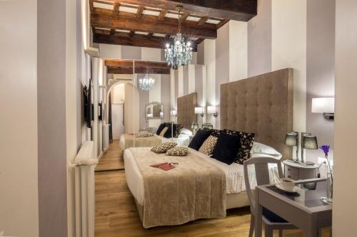 a bedroom with two beds and a table with a desk at The Inn at the Spanish Steps Luxury Collection - The Inn at the Spanish Steps in Rome