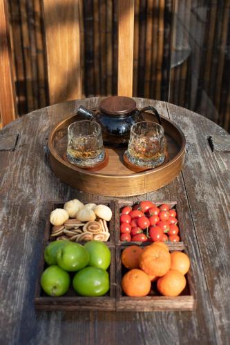 a wooden table with a tray of fruits and vegetables at 雾里观阵山 Foggy Valley in Zhangjiajie