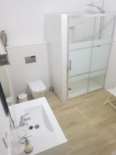 a white bathroom with a sink and a toilet at Casa Rural El Verdinal in Villanueva del Duque