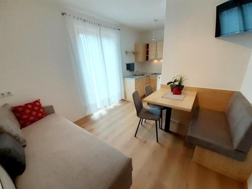 un salon avec un canapé et une table et une cuisine dans l'établissement Fröhlichhof Wohnung Apfelblüte, à Lagundo