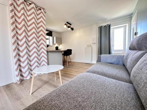 un salon avec un canapé et une table dans l'établissement Au nid du clos cocon a la campagne 10min de Reims, à Courcelles-Sapicourt