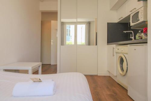 Cette chambre blanche dispose d'un lit et d'un lave-linge. dans l'établissement Le Quatre #Air conditioning #Downtown #Cozy, à Cannes