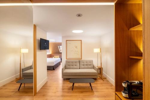 a living room with a couch and a bed at Eurostars Pórtico Alicante in Alicante