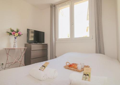 - une chambre avec un lit, des serviettes et une télévision dans l'établissement Le Quatre #Air conditioning #Downtown #Cozy, à Cannes