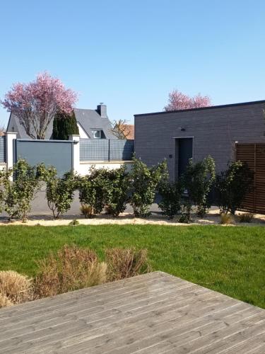 a house with a yard with a wooden deck at La Studette in Bénouville