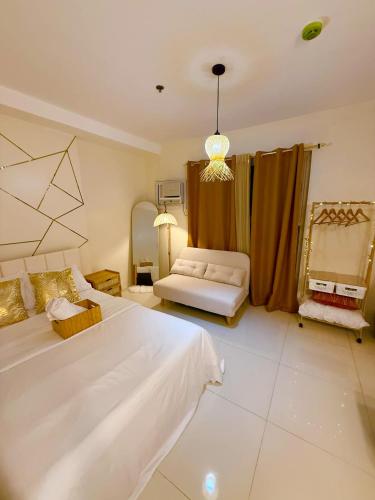 a large bedroom with a bed and a couch at One-Bedroom and Studio Apartment near SM City , IT Park and Ayala Mall - NO PARKING at Bamboo Bay Community in Mandaue City