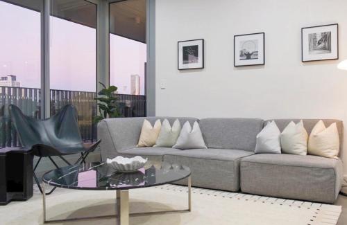 a living room with a couch and a glass table at Modern Minimalist Haven in Sydney