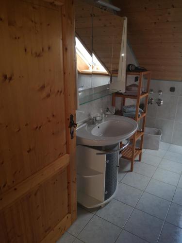 a bathroom with a sink and a wooden door at Antonia in Egling