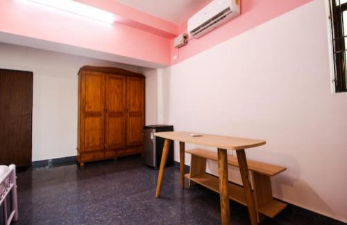 a room with a wooden table and a wooden cabinet at Star Home in Anjuna