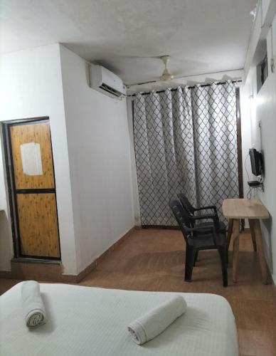a room with a bed and a chair and a table at Star Home in Anjuna