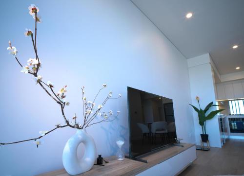 a white vase with flowers in a living room at Sydney Private Home I in Bankstown