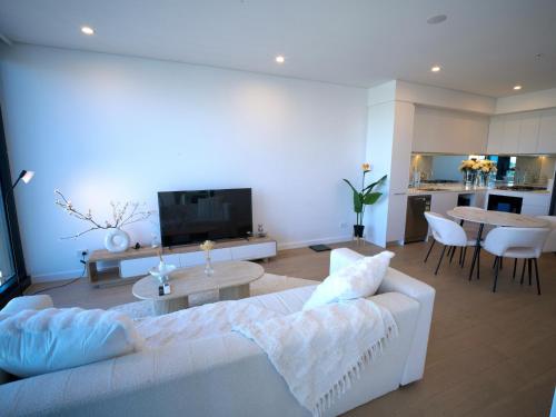 a living room with a white couch and a table at Sydney Private Home I in Bankstown
