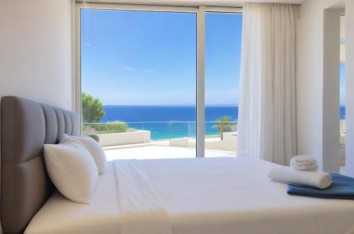 a bedroom with a bed with a view of the ocean at Seaview Luxury Villa Jacuzzi & Pool! 2 Min Beach in Protaras