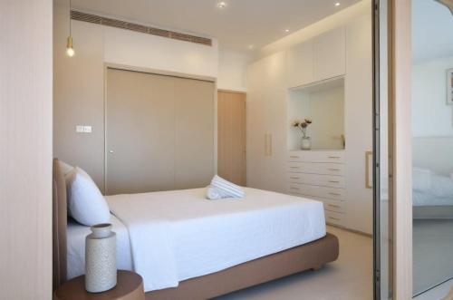 a bedroom with a white bed and a sliding glass door at Seaview Luxury Villa Jacuzzi & Pool! 2 Min Beach in Protaras