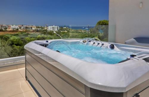 a bath tub in a room with a large window at Seaview Luxury Villa Jacuzzi & Pool! 2 Min Beach in Protaras