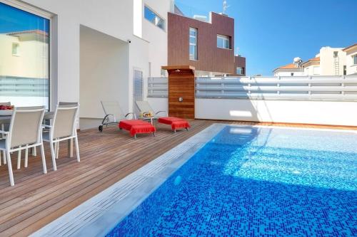 a house with a swimming pool and a table and chairs at Seaview Luxury Villa Jacuzzi & Pool! 2 Min Beach in Protaras
