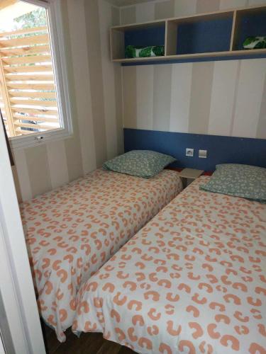 a bedroom with two beds and a window at Gaby mobil Home in Port-la-Nouvelle