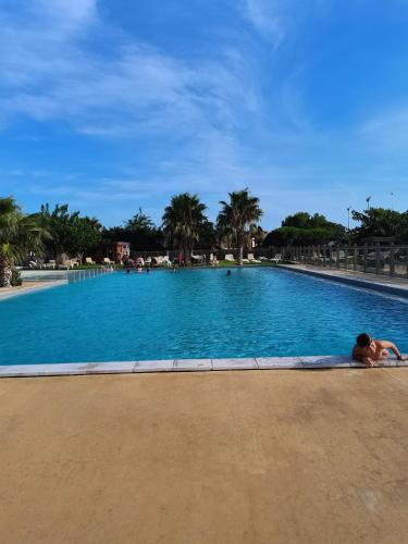 une personne se posant au bord d'une piscine dans l'établissement Gaby mobil Home, à Port-la-Nouvelle