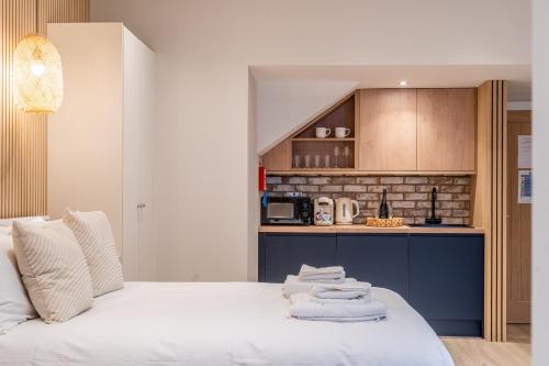 a bedroom with a white bed and a kitchen at Paradise Apartments in York