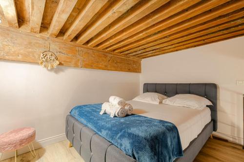 une chambre avec un lit avec un plafond en bois dans l'établissement Caractère et Raffiné en hypercentre, à Lyon