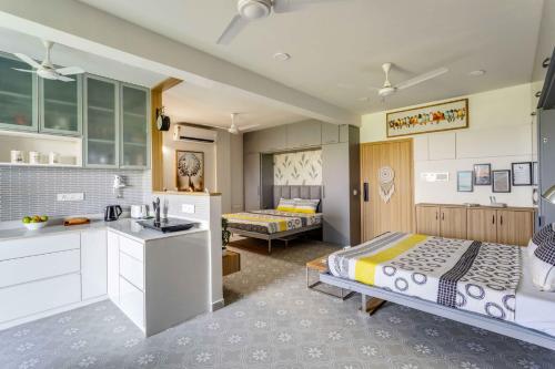a kitchen with two beds and a sink in a room at Mini Paradise Apartment by tisyastays in Candolim
