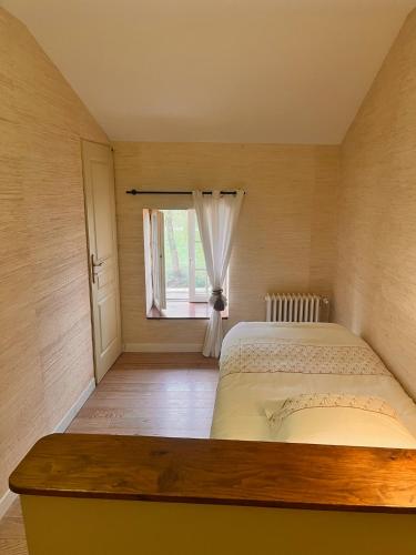 a bedroom with a bed and a window at Moulin De La Parenthèse in Sommières-du-Clain