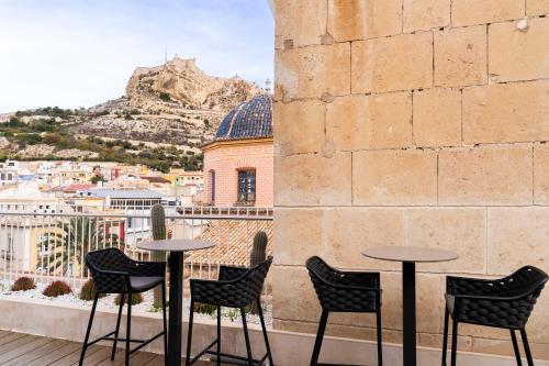 a row of tables and chairs on a balcony with a view at Eurostars Pórtico Alicante in Alicante