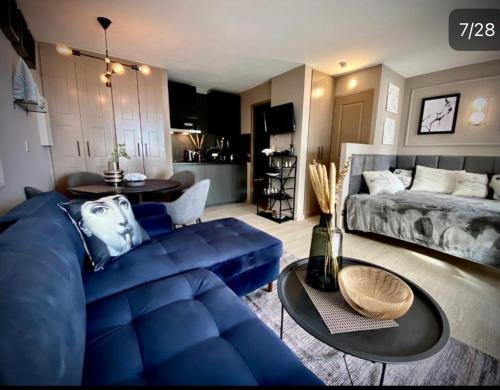 a living room with a blue couch and a bed at Sunny Home Costa Plana-Monaco -Cap D'Ail in Cap d'Ail