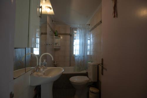 a bathroom with a sink and a toilet and a tub at Cozy 35sm Studio with Free Parking in Áno Varibóbi
