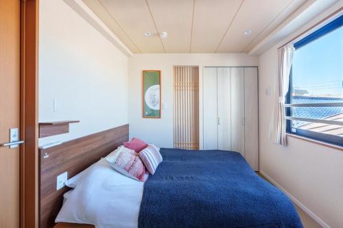 um quarto com uma cama azul e uma janela em 121T MINE HOME野方 nogata MH野方 98m貸切 野方駅から徒歩1分 新宿まで6駅17分 寝室4 広々一軒家 リノベーション em Tóquio